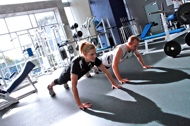 woman and man in charleston gym doing pushups
